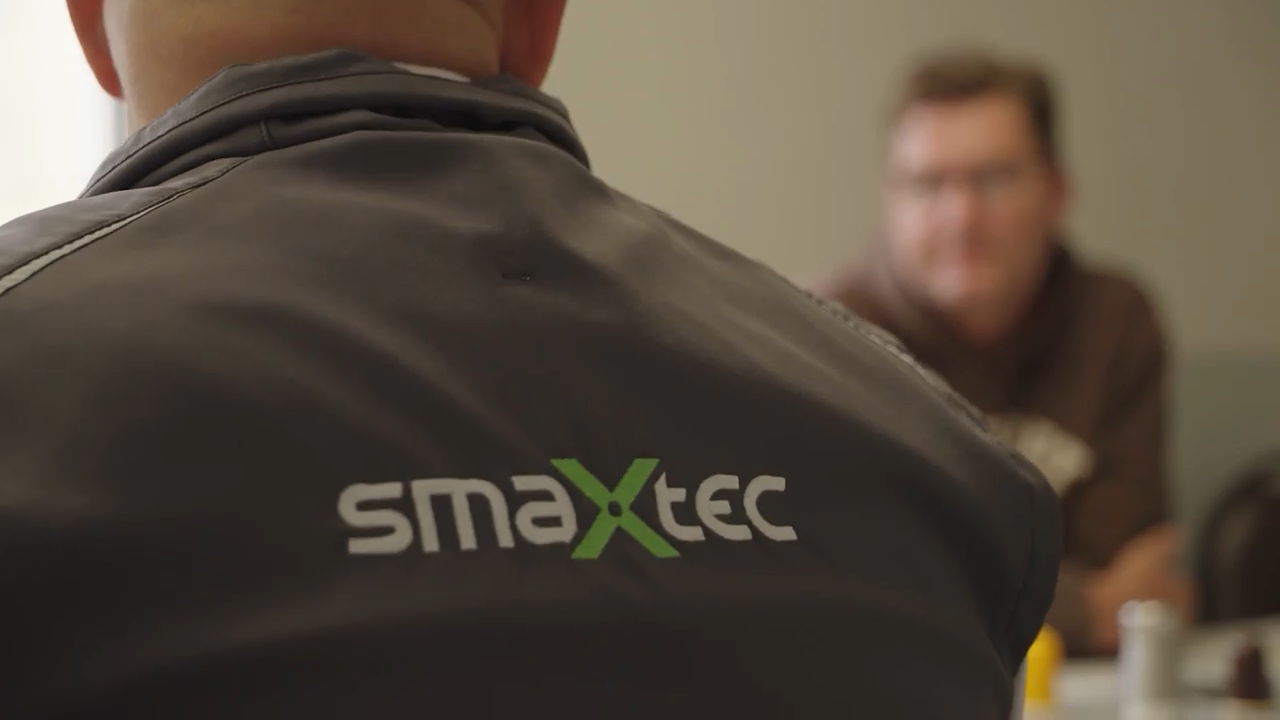 A closeup of the smaXtec logo on the back of a jacket.